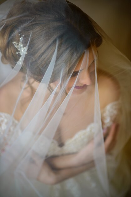 Beautiful bride in her wedding dress under the veil