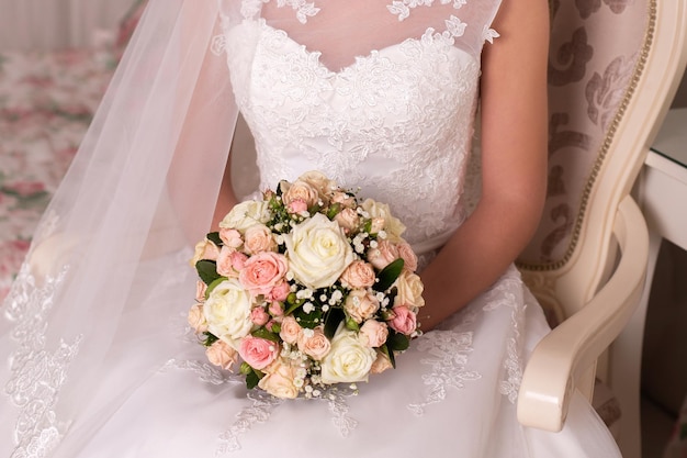 Beautiful bride holding wedding bouquet of roses