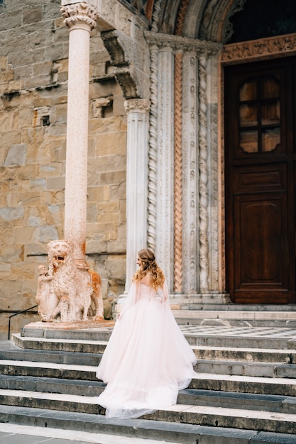 Beautiful bride in a long dress climbs the steps of santa maria maggiore rome italy