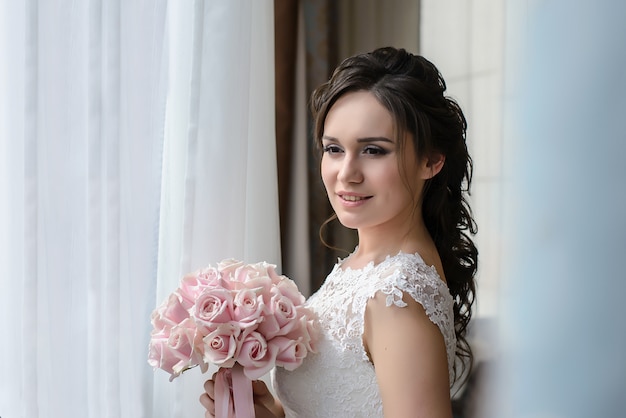 Bella sposa guardando fuori dalla finestra