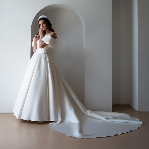 Beautiful bride posing in wedding dress in a white photo Studio