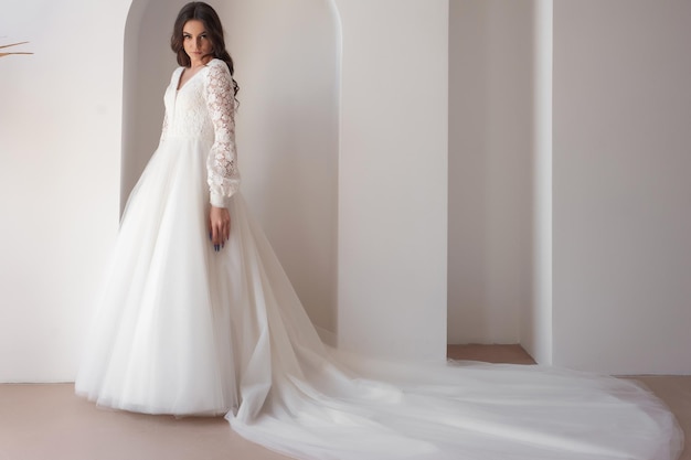 Beautiful bride posing in wedding dress in a white photo Studio