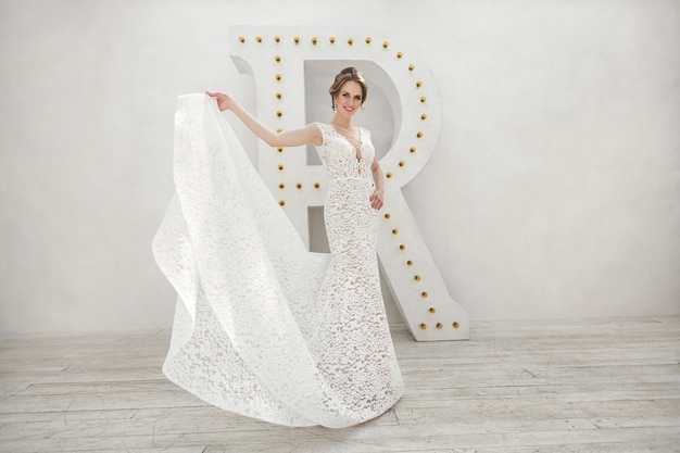 Beautiful bride posing in wedding dress in a white photo Studio