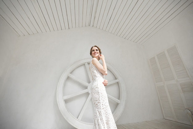 Beautiful bride posing in wedding dress in a white photo studio