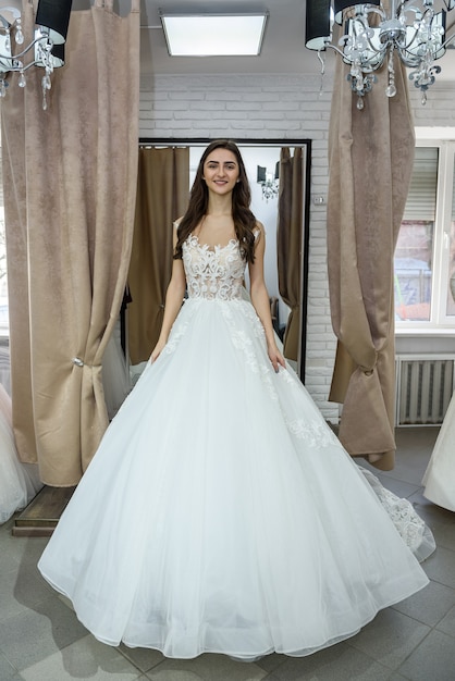 Beautiful bride in salon posing in wedding dress