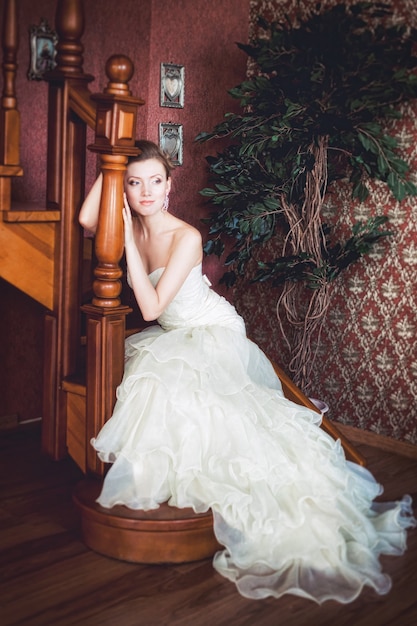 木製の階段に座っている美しい花嫁
