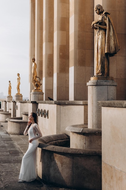 Beautiful bride stands in front of the statues