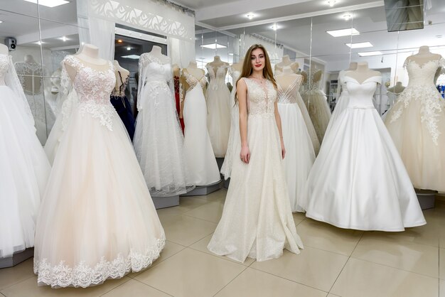 Beautiful bride wearing wedding dress in salon