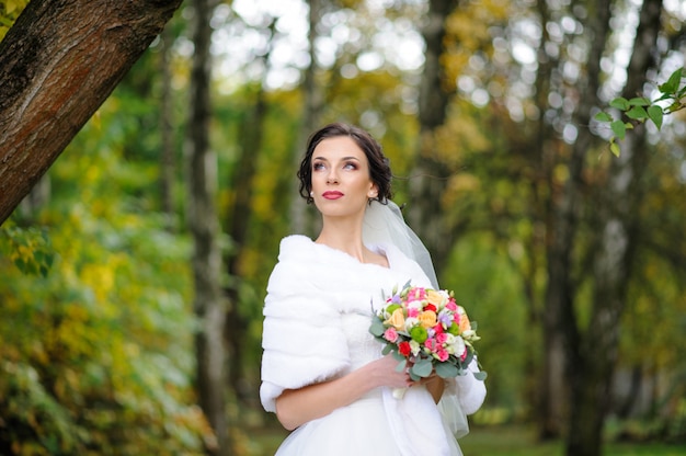 Beautiful bride in wedding dress in the park