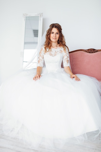 Beautiful bride in a wedding dress with lace, posing in the Studio