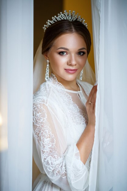 Beautiful bride in a wedding morning in a bathrobe and veil