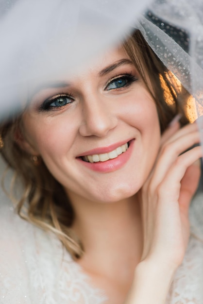 Beautiful bride in white lace lingerie, with bare shoulder sitting in a hotel room. Happy wedding morning.