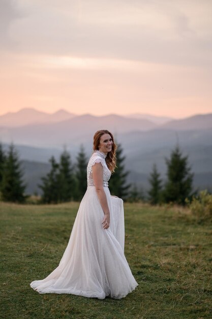 Beautiful bride in a white wedding dress on a background of mountains