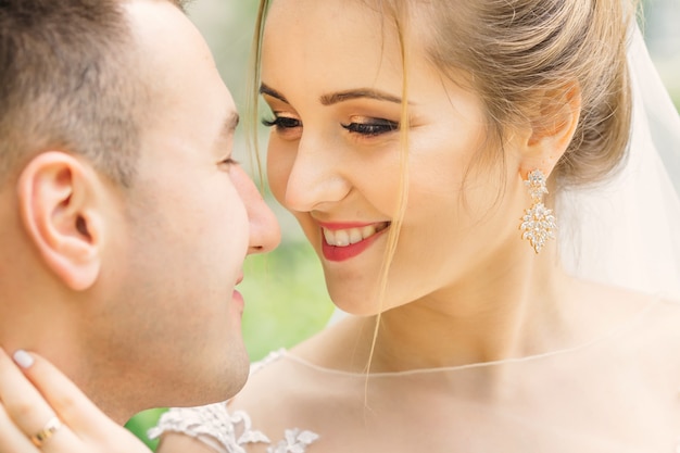 Beautiful bride with gentle makeup looks at the groom and wants to kiss. close up.