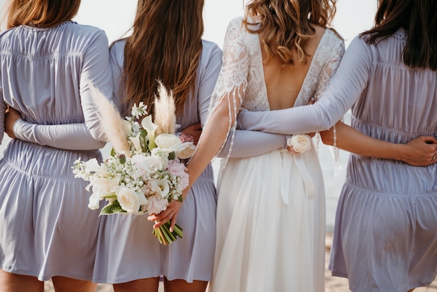 Foto bella sposa con la sua damigella d'onore al matrimonio sulla spiaggia