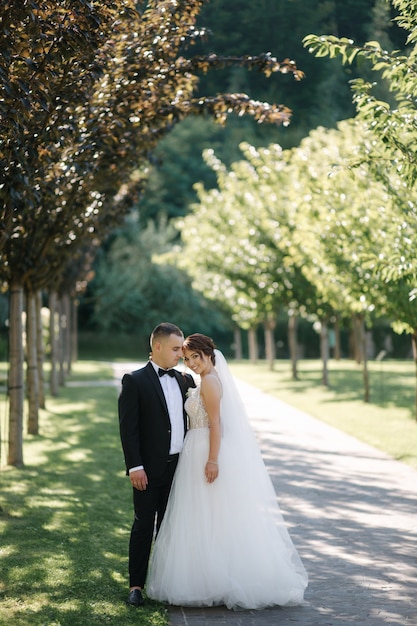 Beautiful bride with her handsome groom walking outside on theri wedding day. Happy newlyweds