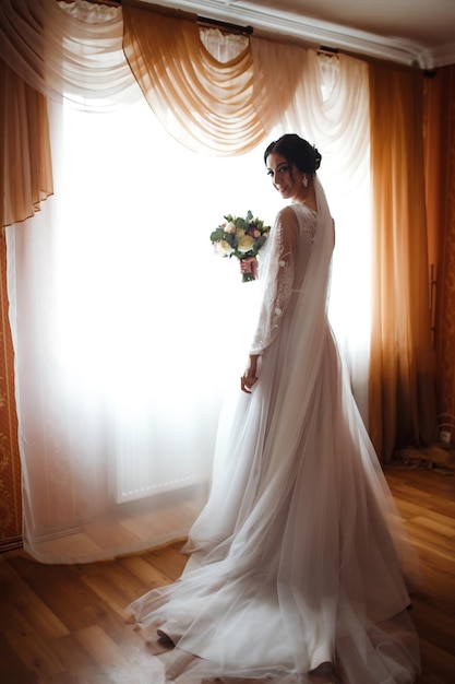 Красивая невеста со свадебным букетом Милая женщина с профессиональным составом, прической. День свадьбы