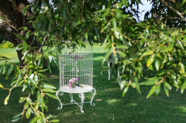 Beautiful brides bouquet in a white cage which is set in beautiful gardens