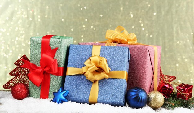 Photo beautiful bright gifts and christmas decor, on shiny background