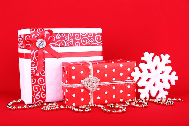 Beautiful bright gifts and Christmas decoration on red background