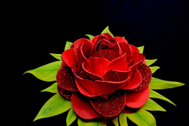 Beautiful bright red rose and green petals