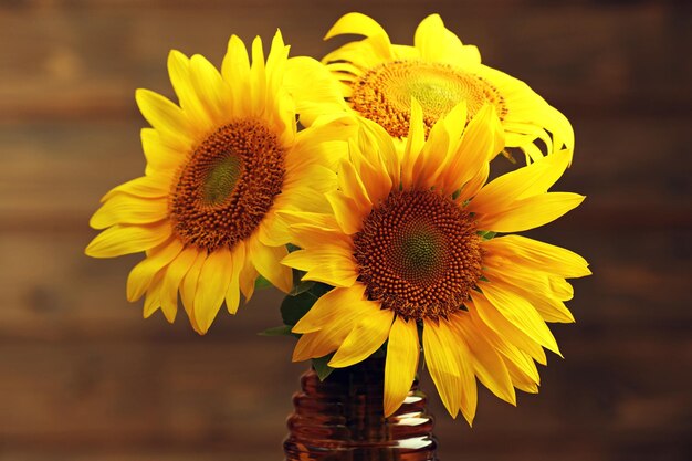 Premium Photo | Beautiful bright sunflowers in vase on wooden background