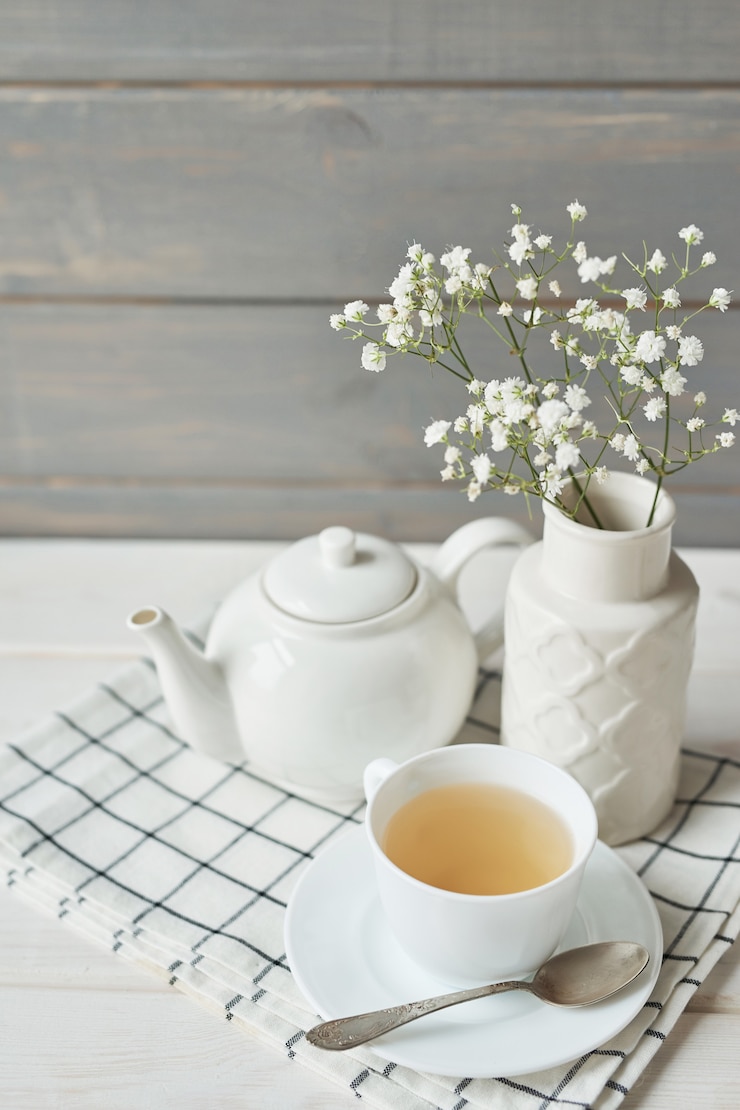 Photo beautiful bright tea set up. white ceramic tea pots and tea ingredients, on top of the white table.