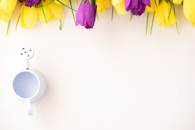 Beautiful bright tulips and watering cans as a concept of flower care.