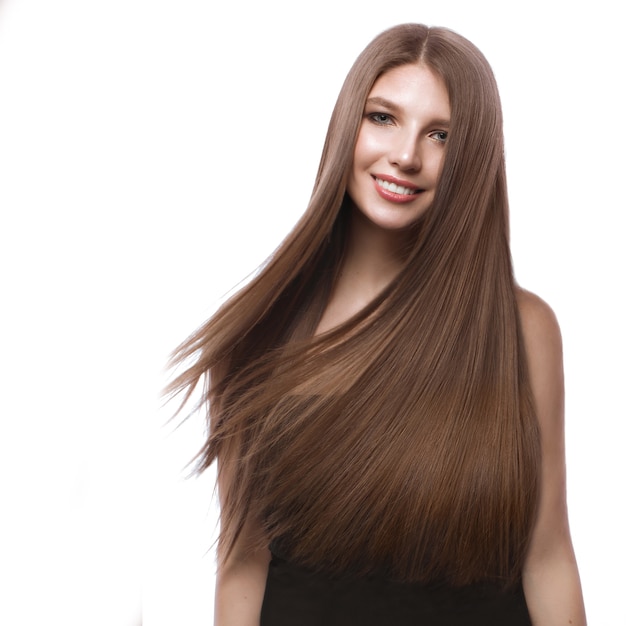 Bella ragazza dai capelli castani in movimento con capelli perfettamente lisci e trucco classico.