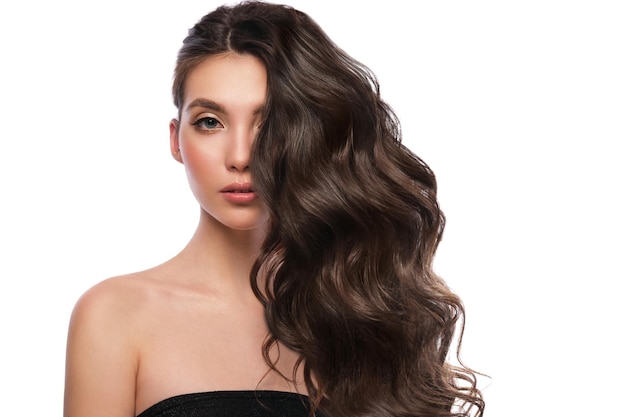 Bella ragazza dai capelli castani con capelli perfettamente arricciati e trucco classico bellezza viso e capelli