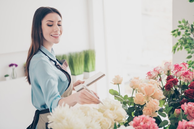 Photo beautiful brunette botanist posing in her flower shop