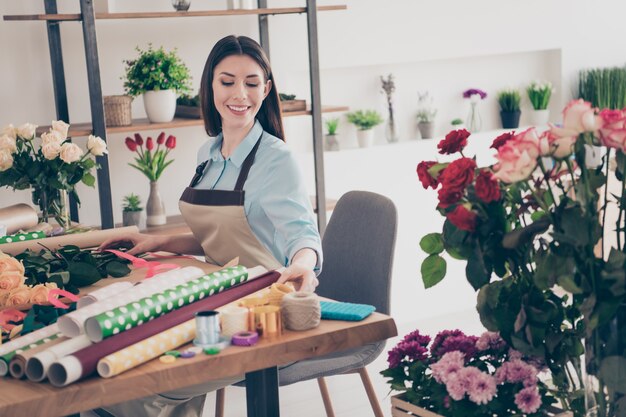 Photo beautiful brunette botanist posing in her flower shop