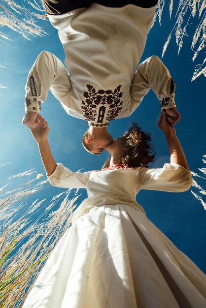 Photo beautiful brunette bride and elegant stylish groom with true happy feelings kissing in a sunny field life conceptxa