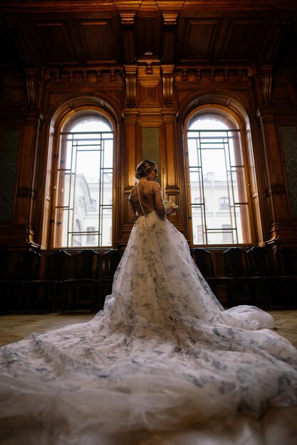 풍부한 빈티지 인테리어의 고급스러운 웨딩 드레스를 입은 아름다운 브루네트 신부