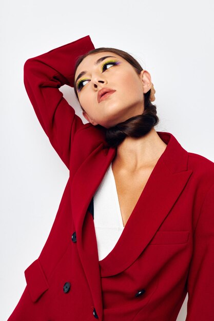 Beautiful brunette bright makeup red jacket posing light background unaltered