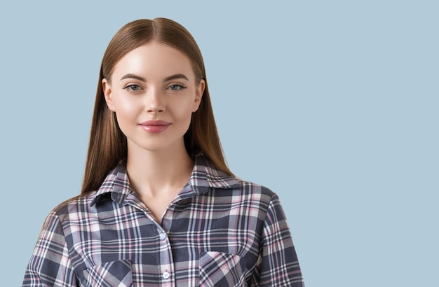 Beautiful brunette in check dress natural portrait. Color background. Blue