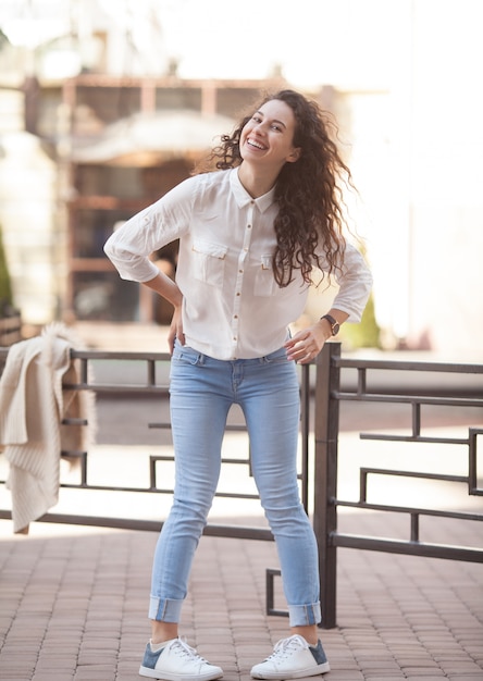 Foto donna riccia del bello brunette che sorride all'aperto