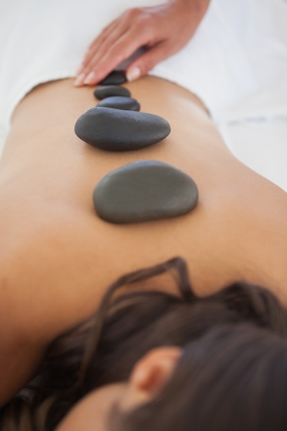 Photo beautiful brunette enjoying a hot stone massage