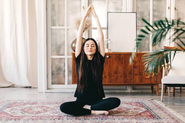 La bella donna castana di forma fisica medita, facendo yoga