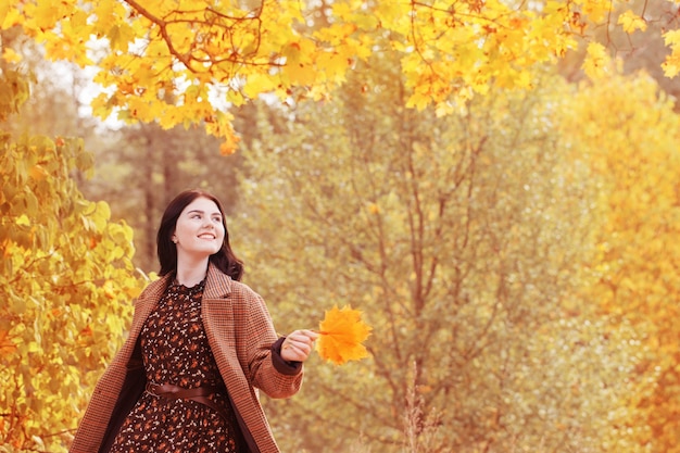 Beautiful brunette girl in autumn park