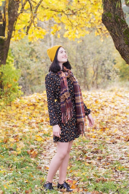 Bella ragazza bruna nel parco d'autunno