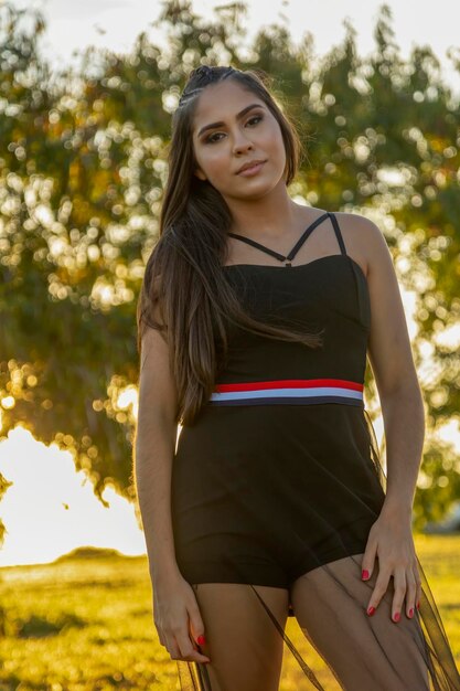 Beautiful brunette girl posing on photos in nature in sunset