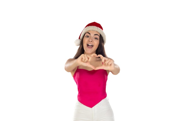 Beautiful brunette girl in santa claus hat isolated on white background with copy space