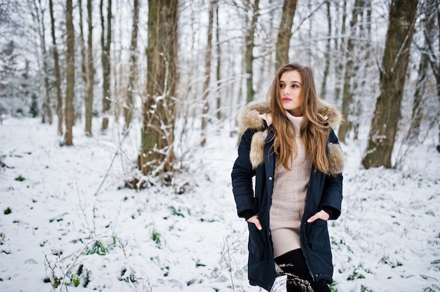 Beautiful brunette girl in winter warm clothing. Model on winter jacket.