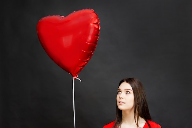 Beautiful brunette girl with a red balloon