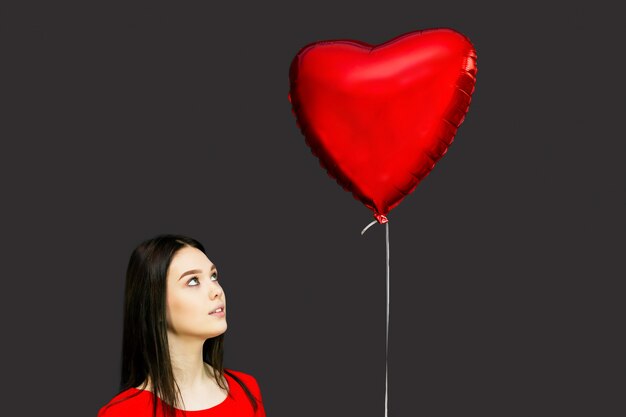 Beautiful brunette girl with a red balloon