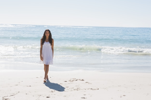 사진 바다에서 걷는 하얀 태양 드레스에 아름 다운 갈색 머리