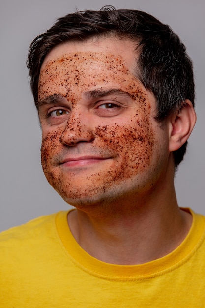 Photo beautiful brunette man with coffee beans mask