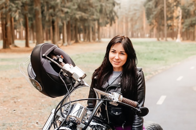 The beautiful brunette riding a motorcycle in the park