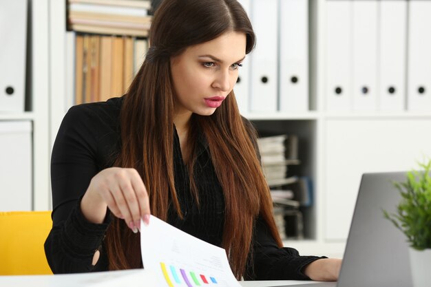 Lavoro sorridente della donna di affari del bello brunette con il computer portatile